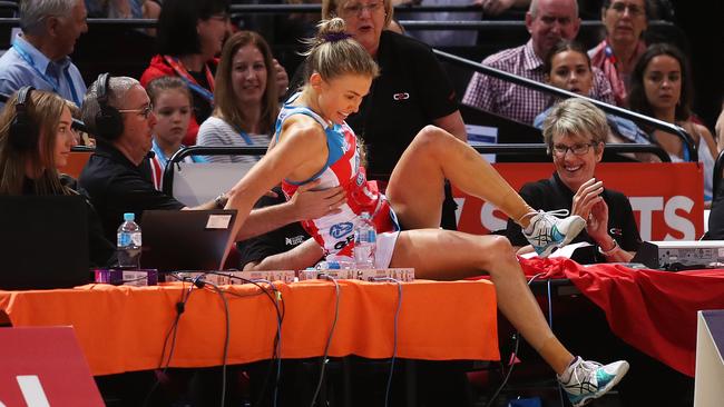 Emily Keenan of the Swifts crashes into the tables courtside. Picture: Brett Costello