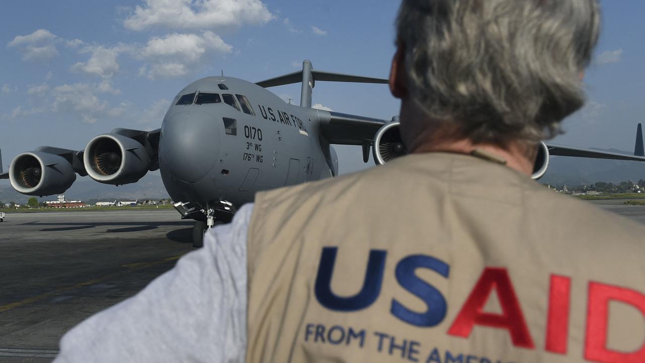 (FILES) A USAID officer watches as a US military C-17 cargo plane taxis to a stop at Kathmandu's international airport on May 3, 2015. Elon Musk says the agency is being shut down. (Photo by Roberto SCHMIDT / AFP)