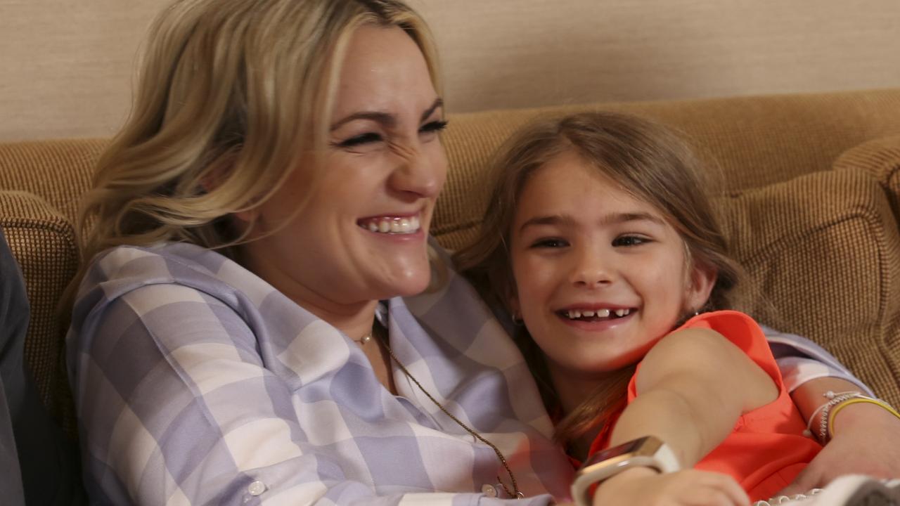 Jaimie Lynn holds Maddie on couch in hotel before a show.