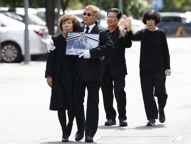 The parents of murdered man Steven Cho, Gum Ja Moon and Jong Yoon Cho with Sang Hwangbo and Jung Hee Hong father and mother of Min Cho, as they farewell the coffins of Steven, Min and Benjamin Cho. Picture: Richard Dobson