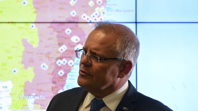 Scott Morrison gets a briefing on the bushfire situation in New South Wales and Queensland during a visit to the Australian Government Crisis Coordination Centre in Canberra on Tuesday.