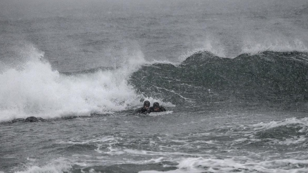 Swedish surfers Pontus Hallin and Lisa Blom attempt to take off with a surfboard made of ice. Picture: AFP