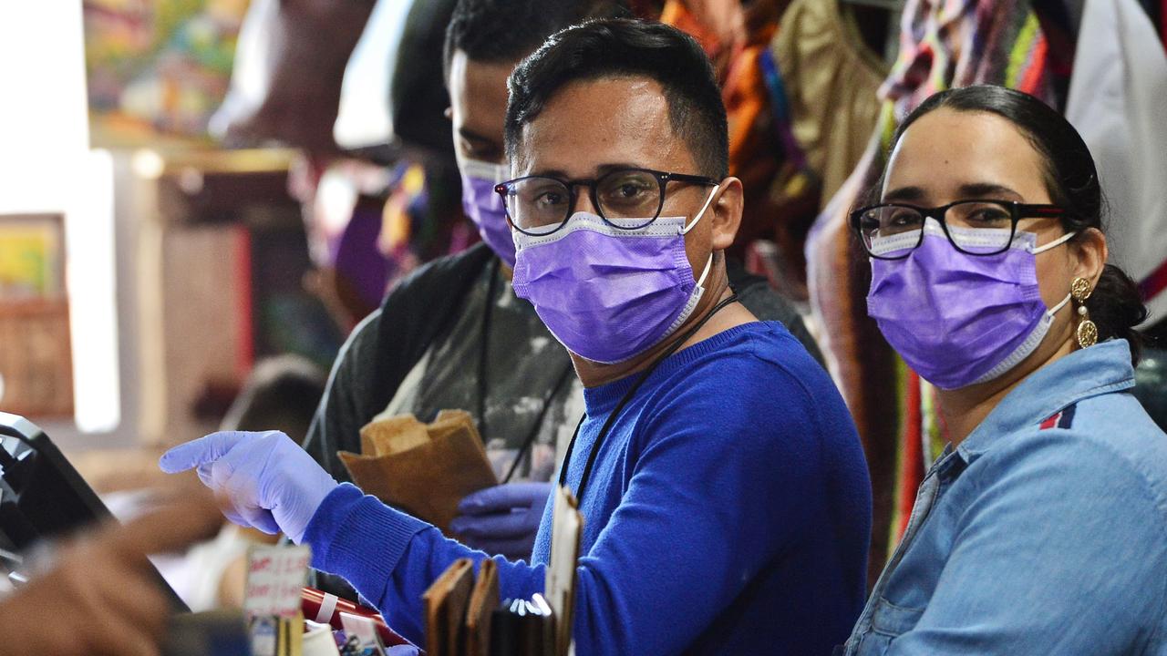 Store workers wear protective face masks as a precaution in Honduras.