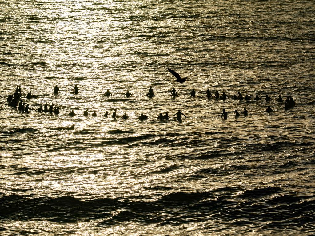 Surfers making there way out to sea to pay tribute to Annalise Braakensiek at the Memorial held at Bondi Beach around 7am Wednesday January 16 Image Picture: Monique Harmer