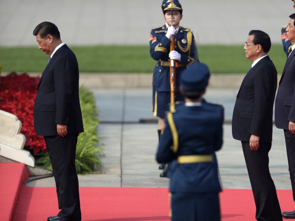 Xi Jinping bows at the steps of the Monument to the People's Heroes during a ceremony to mark Martyr's Day at Tiananmen Square. Picture: Getty