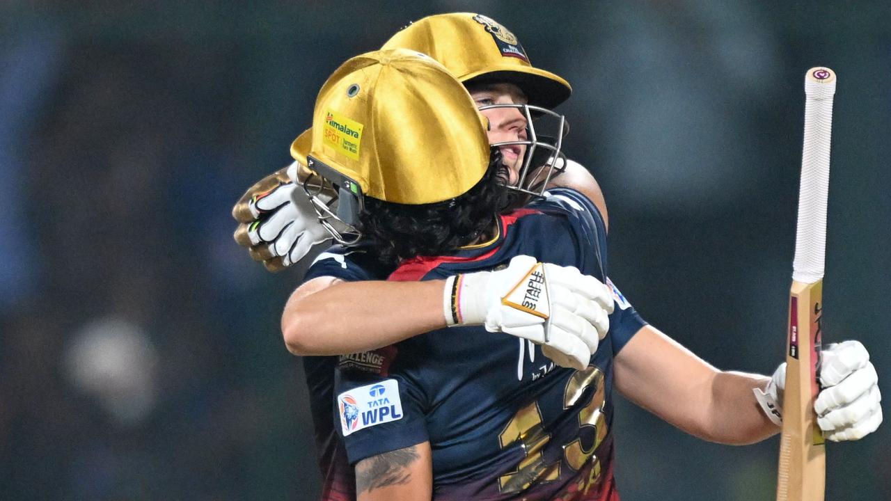 Aussie star Ellyse Perry hugs Richa Ghosh after steering Royal Challengers Bangalore to victory in the WPL final. (Photo by Sajjad HUSSAIN / AFP)