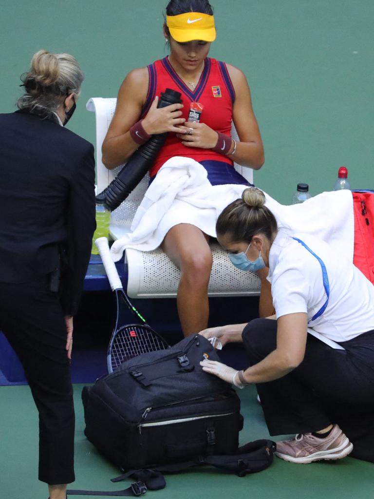 Britain's Emma Raducanu receives medical attention after cutting her knee. (Photo by Kena Betancur / AFP