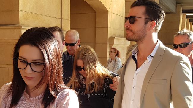 Sharon Tracey Nitschke — centre, wearing sunglasses <ld pattern="."/>— and her supporters leave the District Court. Picture: Sean Fewster.