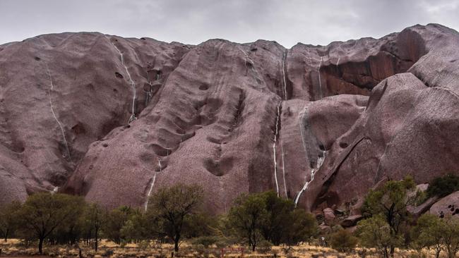 Waterfalls: Water streams down Uluru following heavy rain. Picture: Kartikeya Sharma