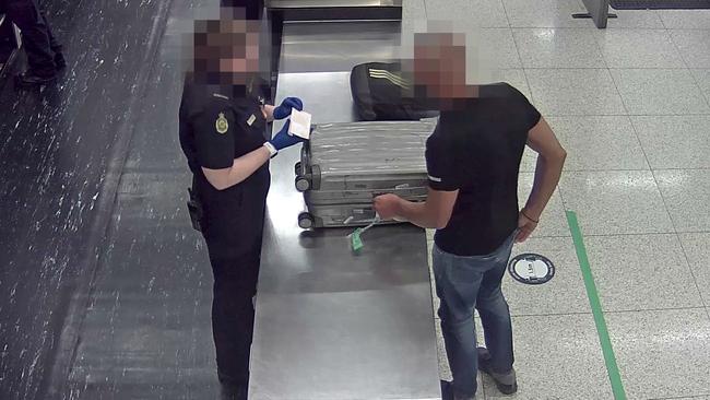 An Australian Border Force officer searches a Bulgarian national’s phone at Perth International Airport in August. Picture: Australian Border Force