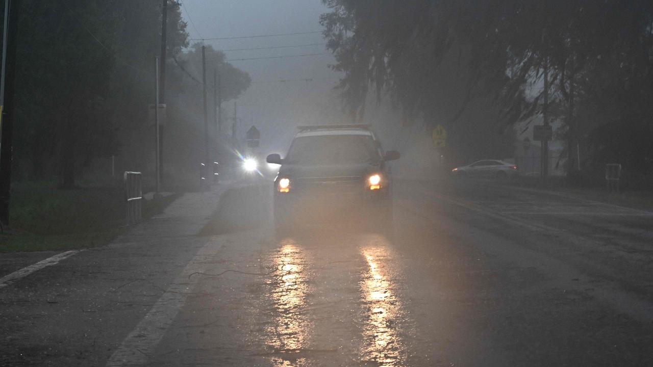 A police car drives through heavy rains in Archer, Florida, on August 30, 2023, after Hurricane Idalia made landfall. (Photo by Chandan Khanna / AFP)