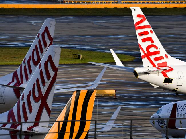 Planes from Australian airlines Tiger Air and Virgin sit idle on the tarmac at Melbourne's Tullamarine Airport on April 12, 2020. - Confinement measures taken around the globe to slow the coronavirus outbreak have forced millions of people to abandon travel plans and stay home, bringing the airline industry to its knees. (Photo by William WEST / AFP)