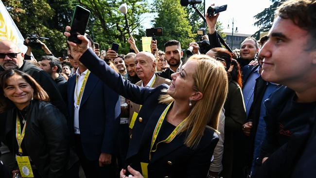 Leader of Italian far-right party "Fratelli d'Italia" (Brothers of Italy), Giorgia Meloni takes a selfie on October 1, 2022 during a visit to the "Villagio Coldiretti" in Milan. Photo: Piero Cruciatti