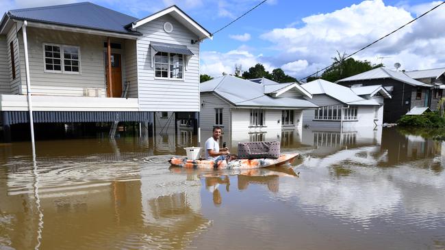 A man kayaks through floodwater in Auchenflower, Brisbane. Picture: Dan Peled