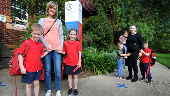 Christelle Dupuy, Noemie, 7 and Nathan, 5 and Vanessa Palmer, Isobel, 1, George, 3, and Henry, 6, at Camberwell Primary School on the first day of term 2. Picture: Andrew Henshaw