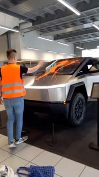 Climate activists drench Cybertruck in orange paint in Tesla showroom