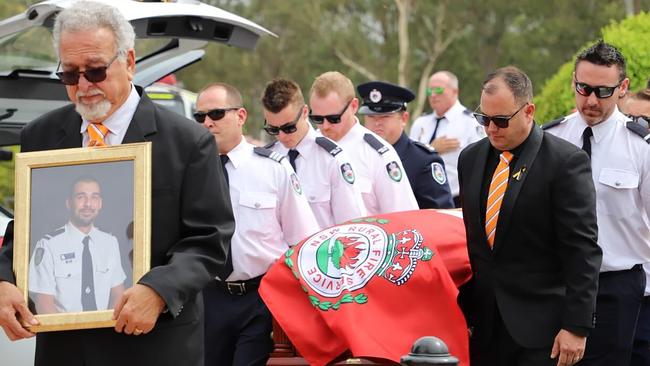 Crew members from Horsley Park RFS carry the casket of RFS volunteer Andrew O’Dwyer during his funeral service on Tuesday. Mr O’Dwyer, 36, and RFS colleague Geoffrey Keaton were killed six days before Christmas when a tree fell in the path of their truck at the still-burning Green Wattle Creek fire, causing it to roll. Picture: Twitter@NSWRFS via AP