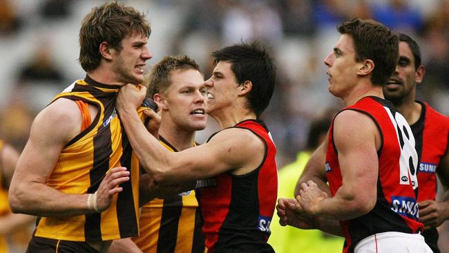 Hawthorn’s Grant Birchall (left) wants a piece of Matthew Lloyd after the Essendon forward bowled over Brad Sewell in 2009.