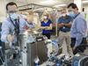 In this June 18, 2020 photo provided by NASA, astronaut Kate Rubins, center, and support personnel review the Universal Waste Management System, a low-gravity space toilet, in Houston. The new device is scheduled to be delivered to the International Space Station on Oct. 1, 2020. (Norah Moran/NASA via AP)