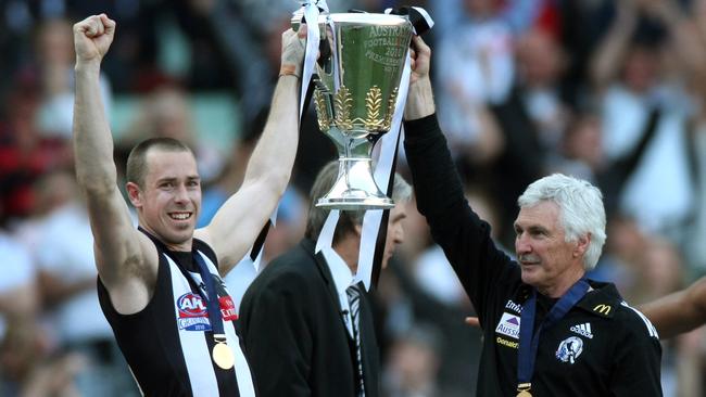 Mick Malthouse and Nick Maxwell lift the 2010 AFL premiership cup.