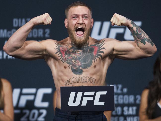 Conor McGregor flexes and yells on the scale during the weigh-ins for UFC 202.