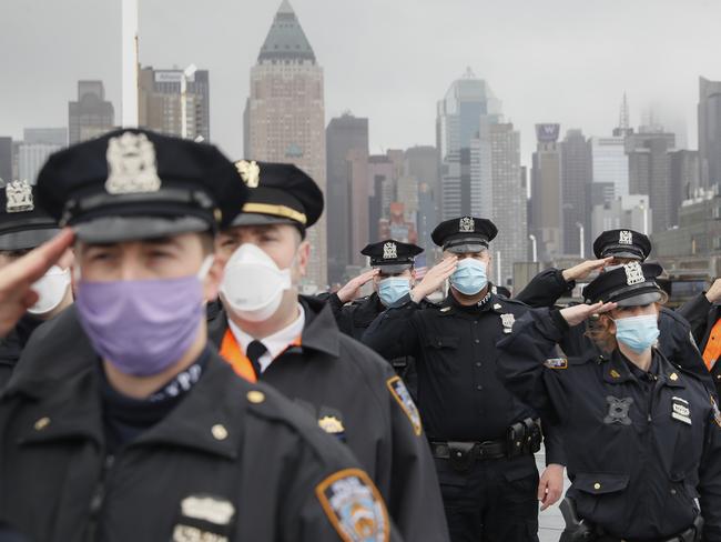 NYPD officers salute the USNS Naval Hospital Ship Comfort as it left New York. Picture: AP