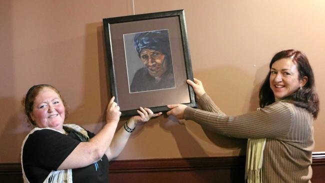 Corina Graham hangs her painting with the help of fellow artist Ann Fogerty. Picture: Sophie Lester