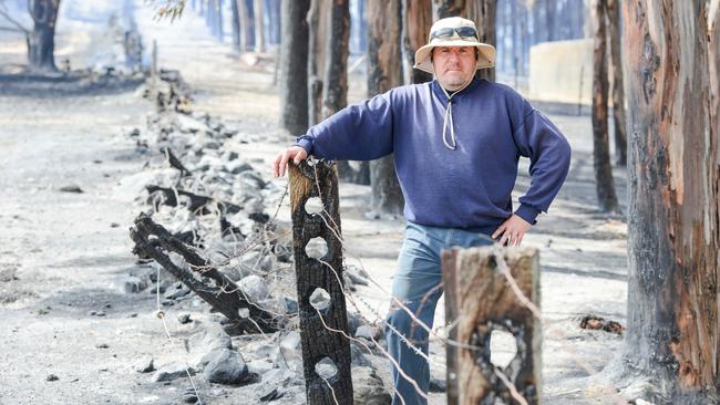 Jim Franklin-McEvoy on his bushfire-damaged property in the Adelaide Hills in December 2019. His house was saved but this 120 year old fence was destroyed. Picture: AAP/ Brenton Edwards