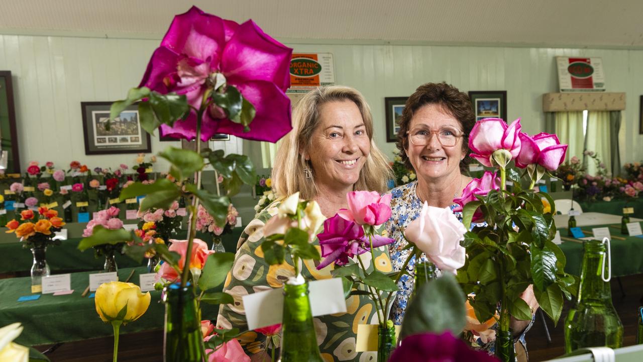 Sally Witherspoon (left) and Gemma McCallum admire the entries of the 2022 Spring Champion Rose Show at the Rose Cottage in the Queensland State Rose Garden, Saturday, October 8, 2022. Picture: Kevin Farmer