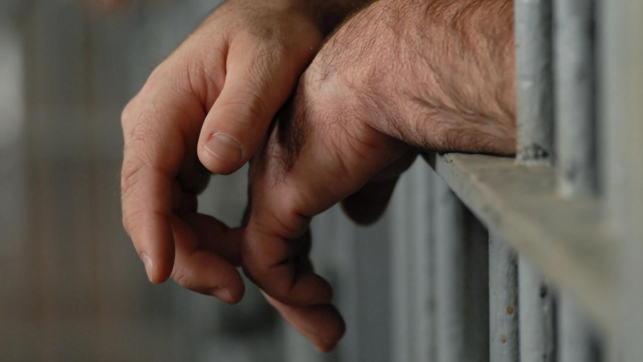 Man behind bars. Jail. Prison. Prisoner. Hands. Generic image.