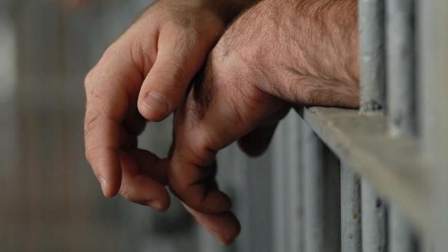 Man behind bars. Jail. Prison. Prisoner. Hands. Generic image.