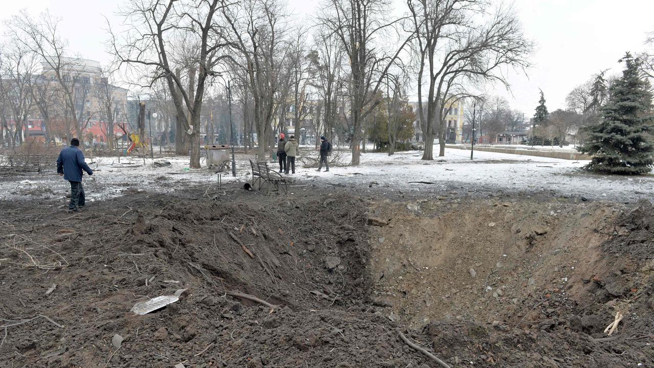 A pedestrian walks past a bomb crater following a shelling in Ukraine's second-biggest city of Kharkiv. Picture: AFP