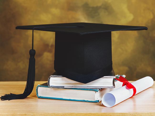 graduation concept.graduation cap,books with degree paper on wood table