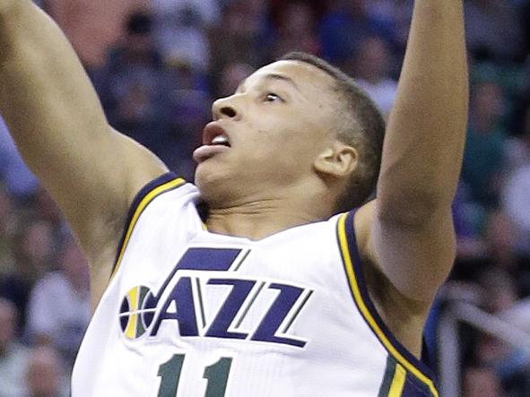 Utah Jazz's Dante Exum (11) lays the ball up as Houston Rockets' Trevor Ariza, right, defends in the first half of an NBA basketball game in Toronto on Wednesday, Oct. 29, 2014. (AP Photo/The Canadian Press, Nathan Denette)
