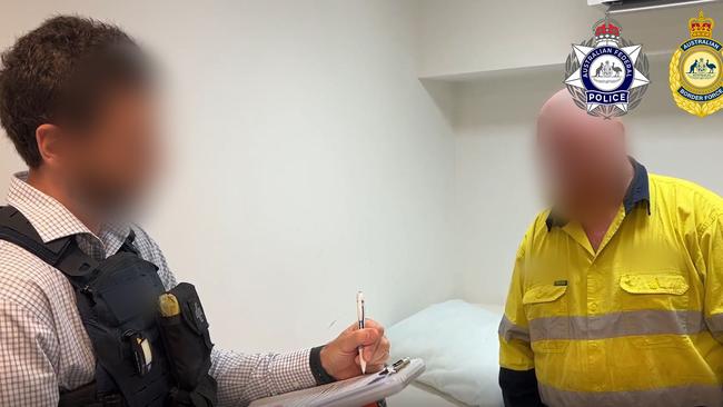 Accused man with AFP investigator. AFP have charged three men after an Esky full of meat and meth was discovered at Christmas Island Airport. Picture: Supplied.