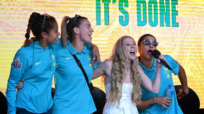 Mary Fowler, Steph Catley and Sam Kerr sing along with Nikki Webster during the Matildas community reception in Brisbane on Sunday. Picture: Bradley Kanaris/Getty Images