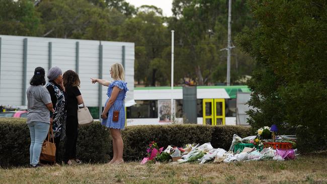 People lay flowers near the Bundoora shopping centre. Picture: AAP 