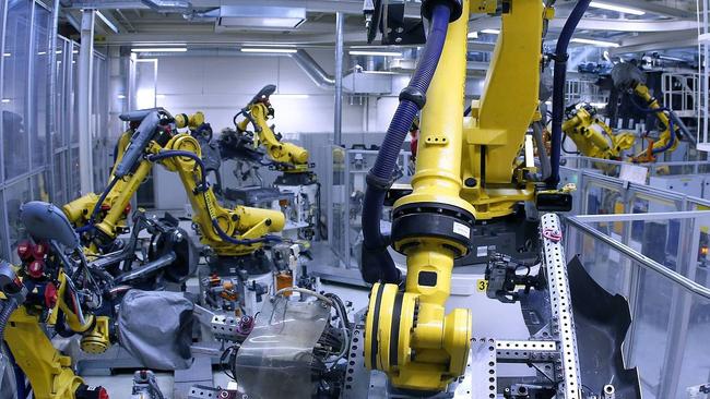 Industrial robots weld parts of chassis of the Volkswagen Golf 7 model at the Volkswagen car factory in Wolfsburg, central Germany, on May 19, 2017. Germany reported a decline in both exports and industrial output in June. PHOTO: AGENCE FRANCE-PRESSE/GETTY IMAGES