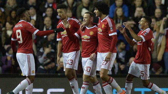 Manchester United's English striker Wayne Rooney (C) celebrates with teammates after scoring his team's first goal during the FA cup fourth round football match between Derby County and Manchester United at Pride Park stadium in Derby on January 29, 2016. / AFP / OLI SCARFF / RESTRICTED TO EDITORIAL USE. No use with unauthorized audio, video, data, fixture lists, club/league logos or 'live' services. Online in-match use limited to 75 images, no video emulation. No use in betting, games or single club/league/player publications. /