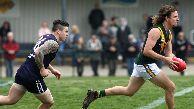 Yarra Junction’s Kurt Robb runs off Seville’s James Cecere. Picture: Hamish Blair