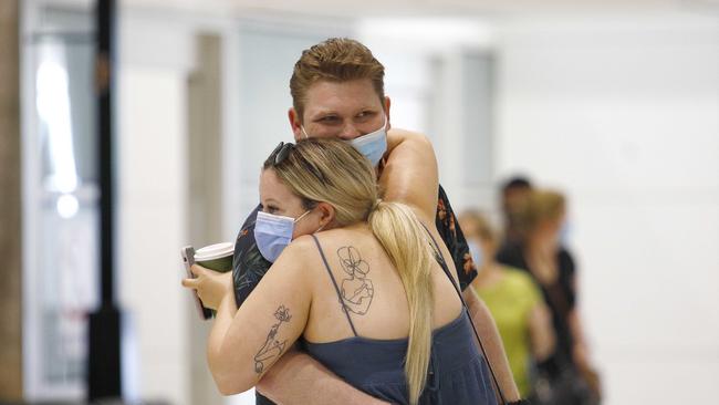 A couple embrace at Brisbane Airport. Picture: NCA NewsWire/Tertius Pickard