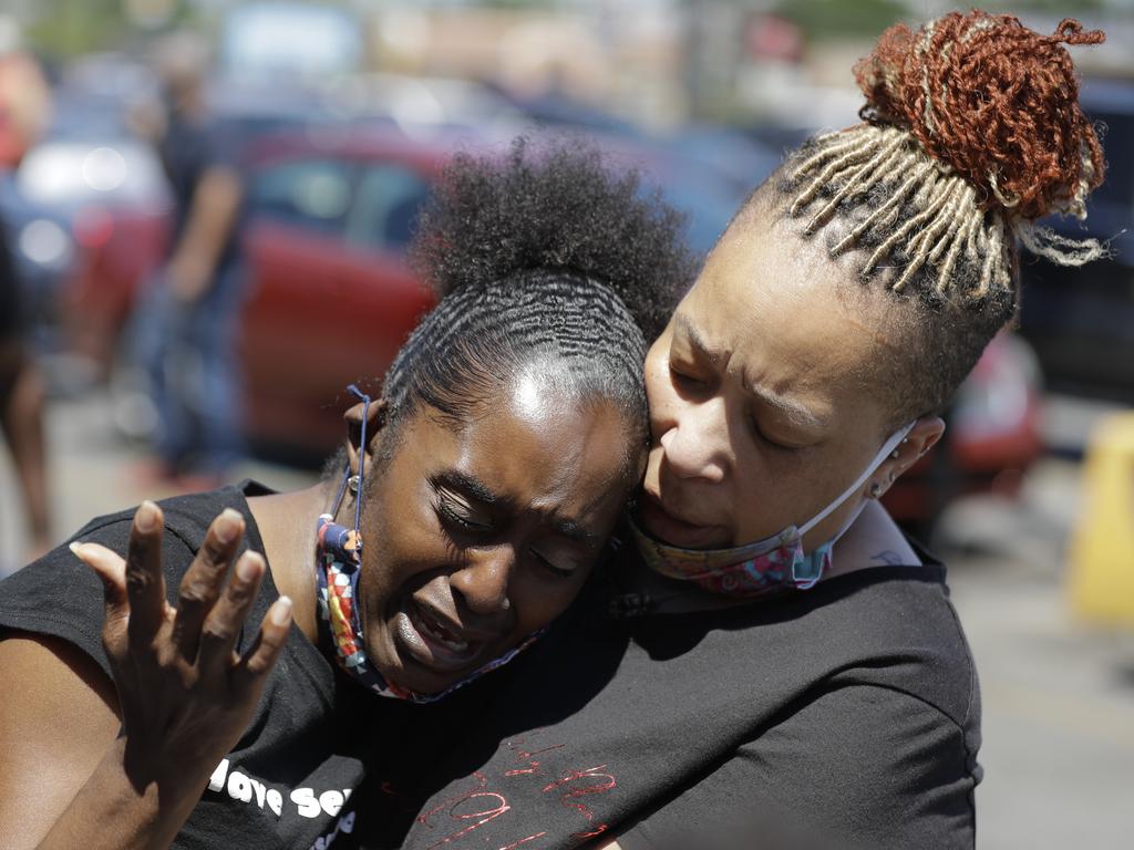 Two women pray in Louisville near the intersection where David McAtee was killed Sunday evening. Picture: Darron Cummings/AP