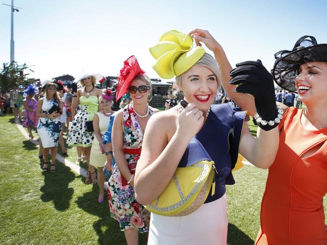 Lining up for Myer Fashions in the Field, hopeful Melanie Plane puts on a last minute touch up with the help of friend Katie Halstead at the 2014 Melbourne Cup. Picture: David Caird.