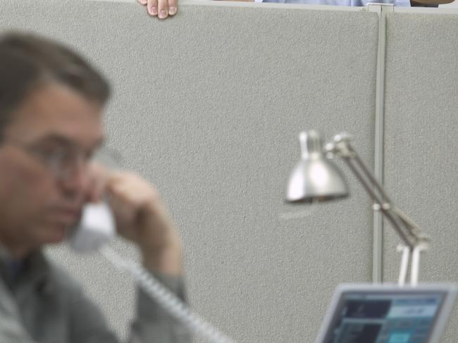 Caucasian Male Office Worker Throwing A Paper Airplane At His Cubicle Neighbor