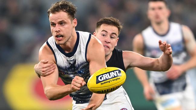 Jake Kolodjashnij of the Cats handballs while being tackled by Matthew Owies of the Blues during the round 17 AFL match between Carlton Blues and Geelong Cats. (Photo by Quinn Rooney/Getty Images)