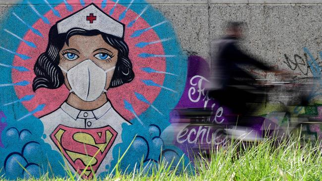 Nurses are being applauded around the world, including through this artwork by Kai 'Uzey' Wohlgemuth in Germany, depicting a nurse as Superwoman. Picture: AFP