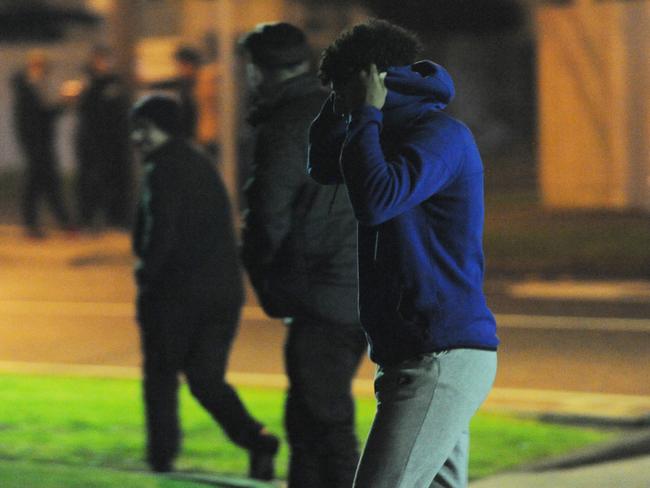 Onlookers after police attended a party in Reservoir. Picture: Andrew Henshaw