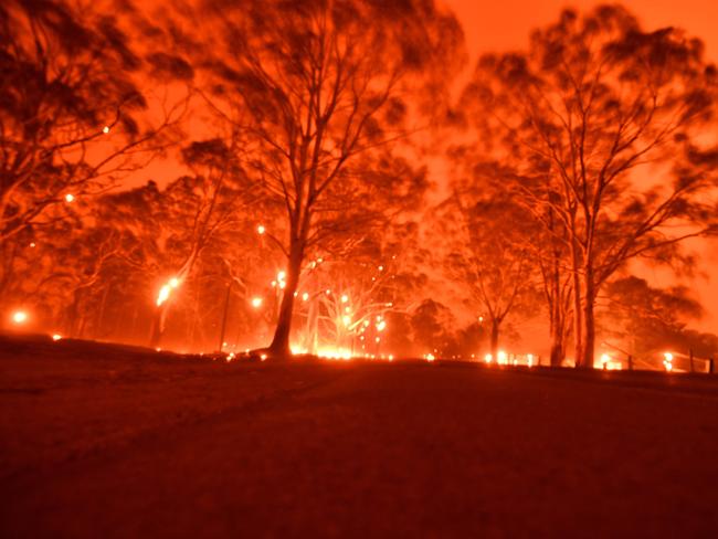 The afternoon sky glows orange from bushfires in the area around the town of Nowra in the Australian state of New South Wales on December 31, 2019. - Thousands of holidaymakers and locals were forced to flee to beaches in fire-ravaged southeast Australia on December 31, as blazes ripped through popular tourist areas leaving no escape by land. Picture: Saeed Khan/AFP