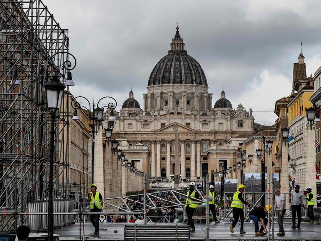 Workers build a tribune with the St Peter's Basilica of the Vatican in the background, on Via della Conciliazione street in Rome. Picture: AFP
