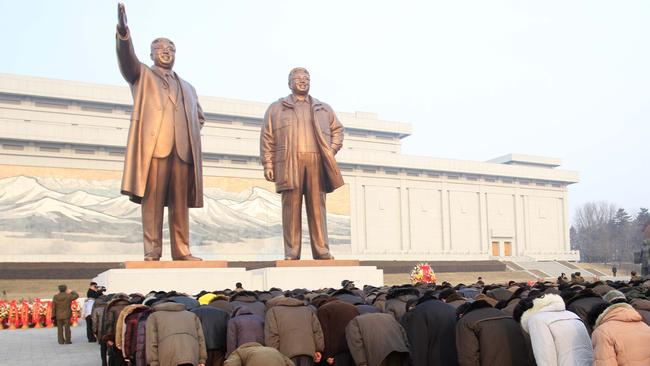 Crowds bow to the statues of North Korea's late leader Kim Jong Il, right, and his father, North Korea's founder Kim Il Sung.